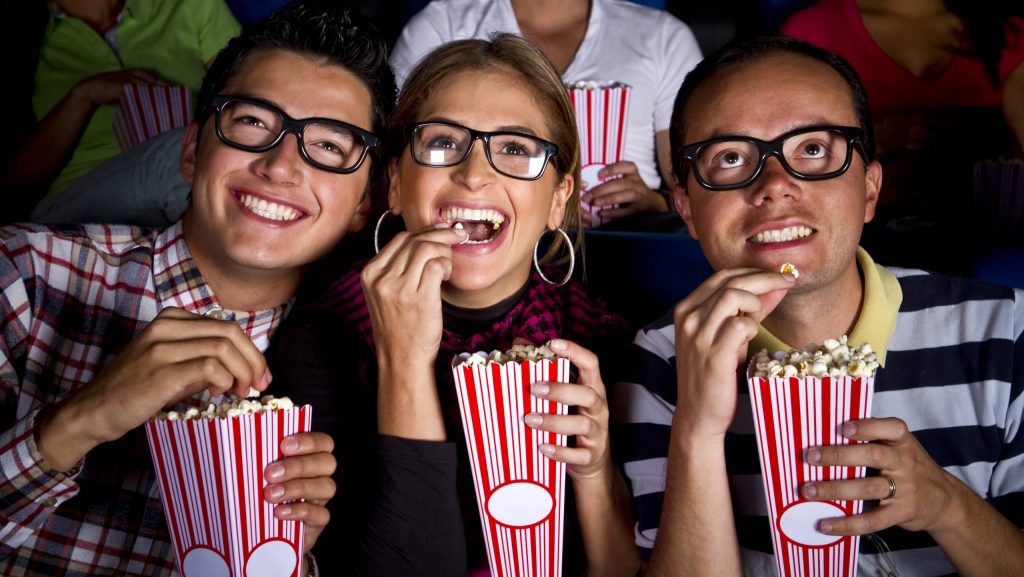 Hispanic friends enjoying popcorn at movie theater Bogota, Cundinamarca, Colombia, 21.12